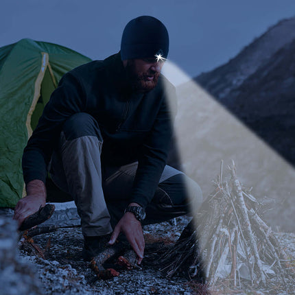 Person using the PowerCap beanie to see while making a fire