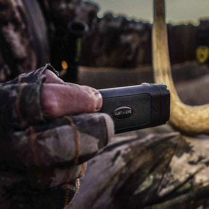 Hunter using flat-eyed flashlight to look at the horns of a buck