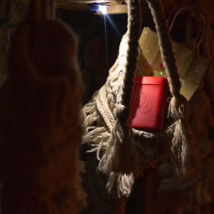 Button lamp light attached underneath a fireplace ledge lighting a stocking stuffed with a Power Paw hand warmer