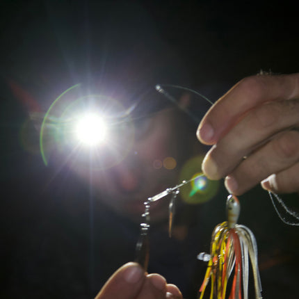 man holding fishing tackle wearing an LED lighted headlamp beanie