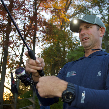 fisherman in the woods wearing a grey LED lighted headlamp hat
