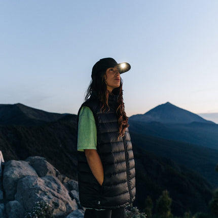 woman on top of a mountain wearing an LED lighted hat