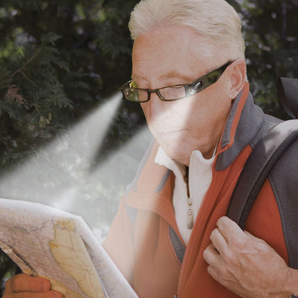 Person using lighted reading glasses to read a map