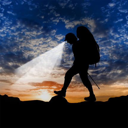Hiker with lighted cap walking in the dark