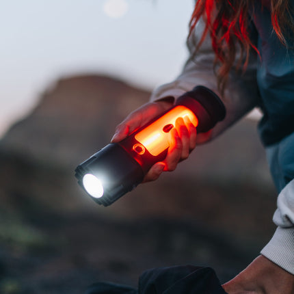 close up of a female hiker holding a rechargeable LED lantern flashlight