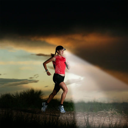 woman in athletic wear and a POWERCAP 25/75 LED lighted running hat running on a trail