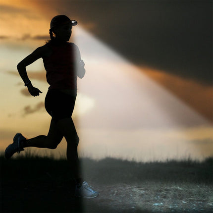 woman running on a trail at sunrise wearing a POWERCAP 25/75 LED lighted running hat